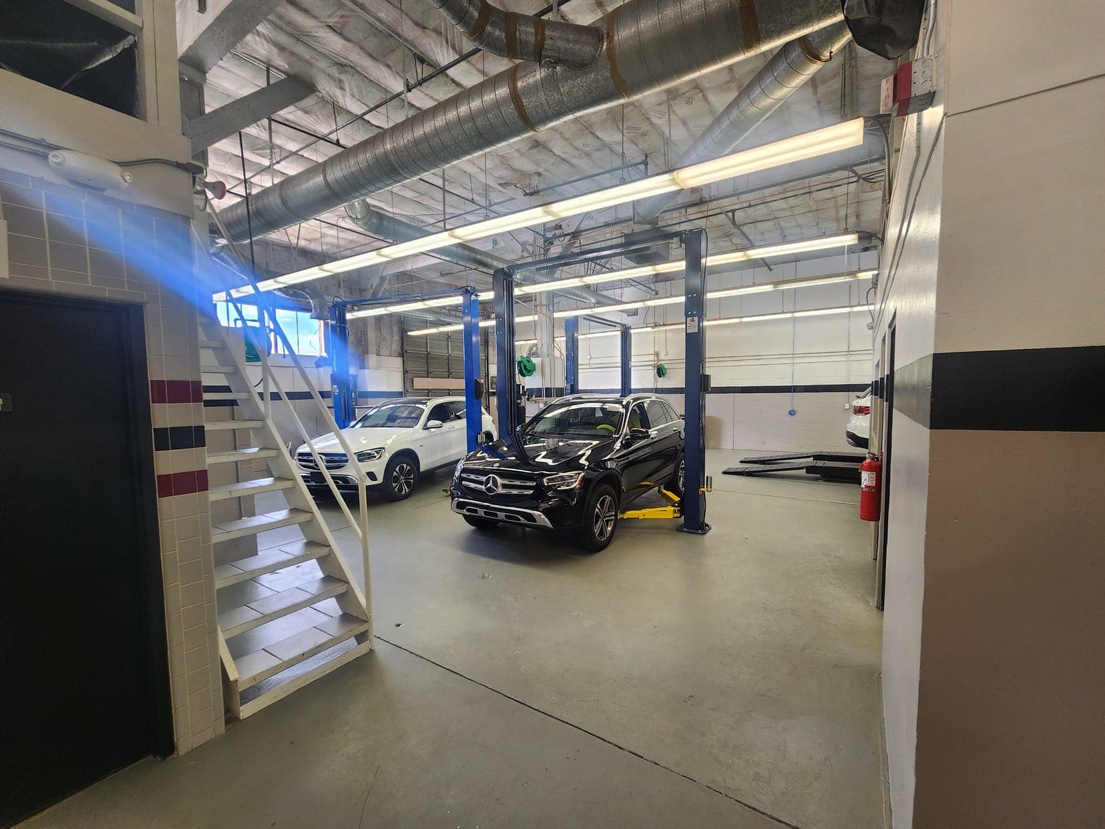 Multi-lift automotive service bay with Mercedes-Benz vehicles on lifts