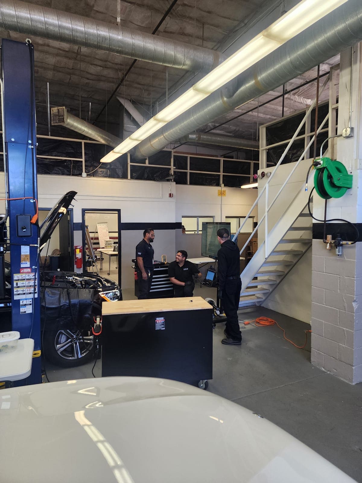 Students performing vehicle assembly and mechanical component work