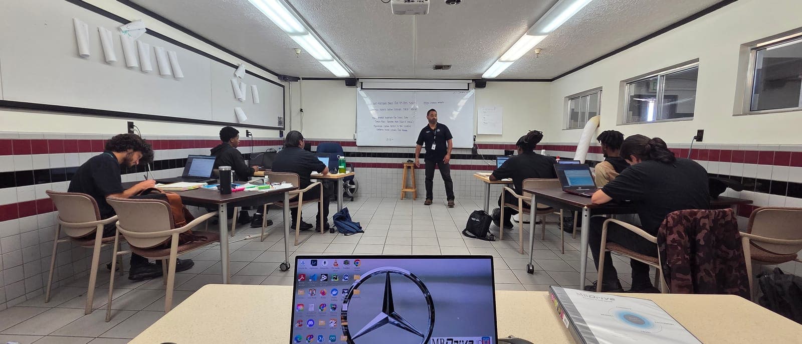Classroom environment with student stations and instructor presenting